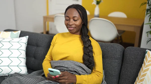 Afrikanerin Sitzt Mit Smartphone Hause Auf Sofa — Stockfoto