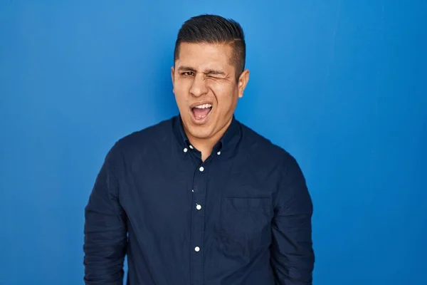 Hispanic Young Man Standing Blue Background Winking Looking Camera Sexy — Stock Fotó