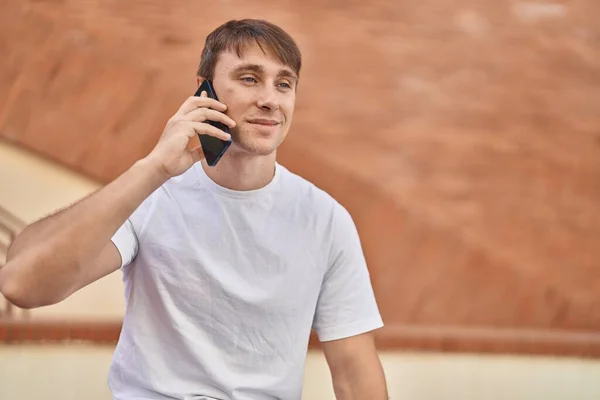 Молодой Кавказский Мужчина Улыбается Уверенно Разговаривая Смартфону Улице — стоковое фото