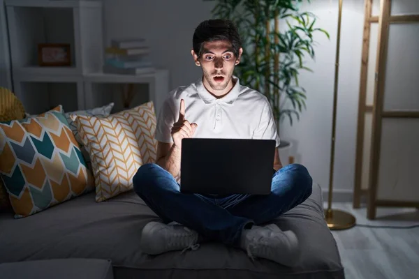 Jovem Hispânico Usando Laptop Casa Noite Espantado Surpreso Olhando Para — Fotografia de Stock