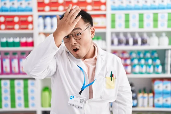 薬局で働く中国の若者は ミスのために頭の上に手で驚いて エラーを覚えている 忘れられた悪い記憶の概念 — ストック写真