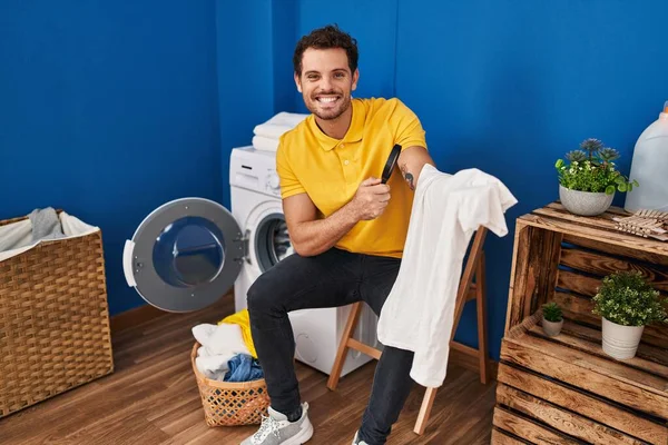 Joven Hombre Hispano Buscando Camiseta Limpia Con Lupa Lavandería —  Fotos de Stock