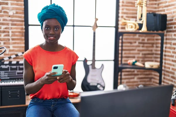 年轻的非洲裔美国女音乐家在音乐中使用智能手机 — 图库照片