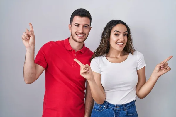 Young Hispanic Couple Standing Isolated Background Smiling Confident Pointing Fingers — Stock Photo, Image