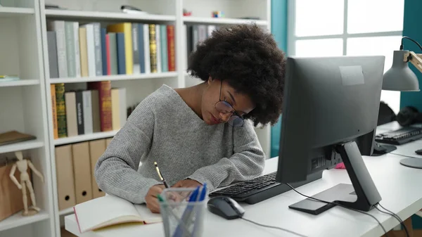 アフリカ系アメリカ人の女子学生が図書館大学のノートにコンピュータ ライティングを使って — ストック写真