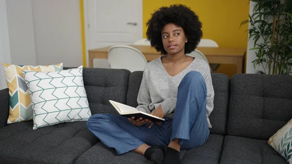 African American Woman Reading Book Sitting Sofa Home — Foto de Stock