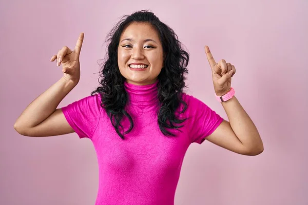 Jonge Aziatische Vrouw Staan Roze Achtergrond Glimlachen Verbaasd Verrast Wijzen — Stockfoto