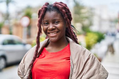 Sokakta kendine güvenen Afrikalı Amerikalı kadın gülümsüyor