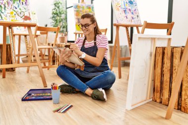 Sanat stüdyosunda kendine güvenen genç bir kadın.