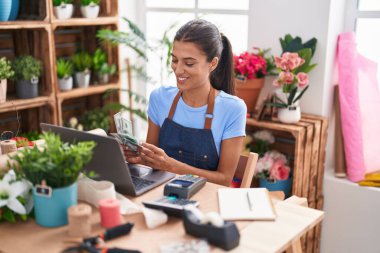 Çiçekçiye para sayan güzel İspanyol kadın.