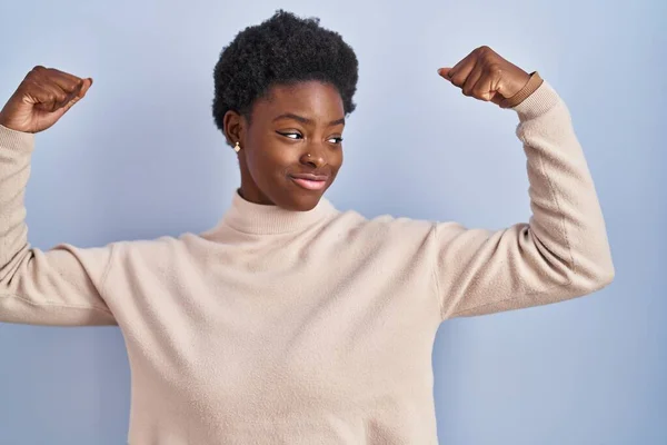 African American Woman Standing Blue Background Showing Arms Muscles Smiling — Fotografia de Stock