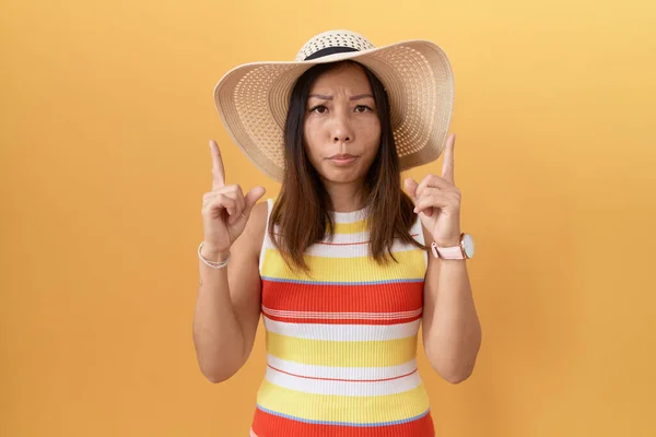 中世中国の女性は 指で方向を示す 悲しいと動揺を指して黄色の背景に夏の帽子を身に着けている 不幸なと落ち込んで — ストック写真