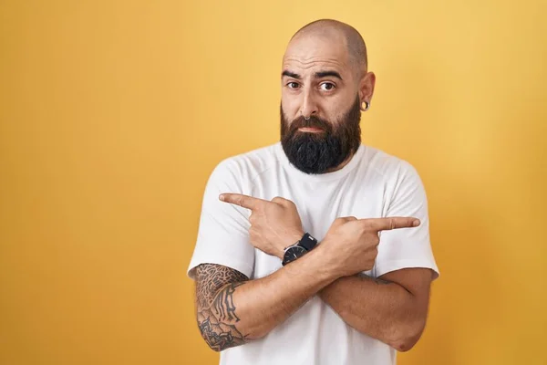 Young Hispanic Man Beard Tattoos Standing Yellow Background Pointing Both — Stock Photo, Image