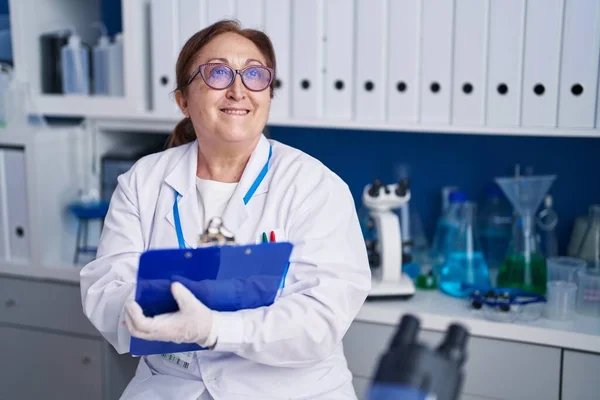 Senior Γυναίκα Επιστήμονας Χαμογελά Αυτοπεποίθηση Γράφοντας Στο Έγγραφο Στο Εργαστήριο — Φωτογραφία Αρχείου