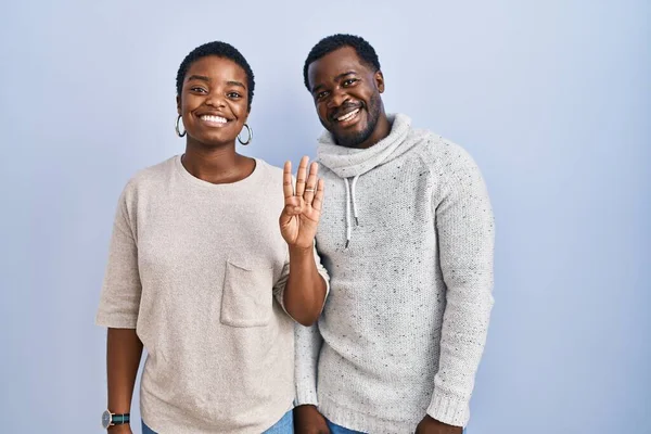 一对年轻的非洲裔美国夫妇站在蓝色的背景上 用第四指尖 面带微笑 自信而快乐 — 图库照片