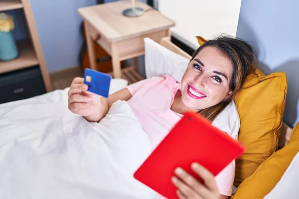 Young Beautiful Hispanic Woman Using Touchpad Credit Card Lying Bed — Stock fotografie