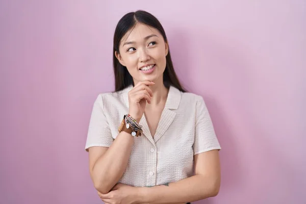 Chinese Jonge Vrouw Staan Roze Achtergrond Met Hand Kin Denken — Stockfoto