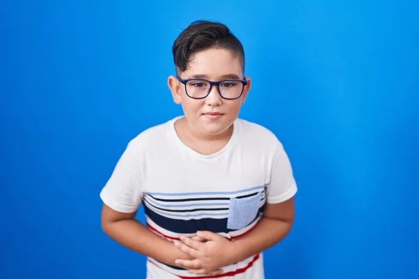 Niño Hispano Joven Pie Sobre Fondo Azul Con Mano Estómago — Foto de Stock
