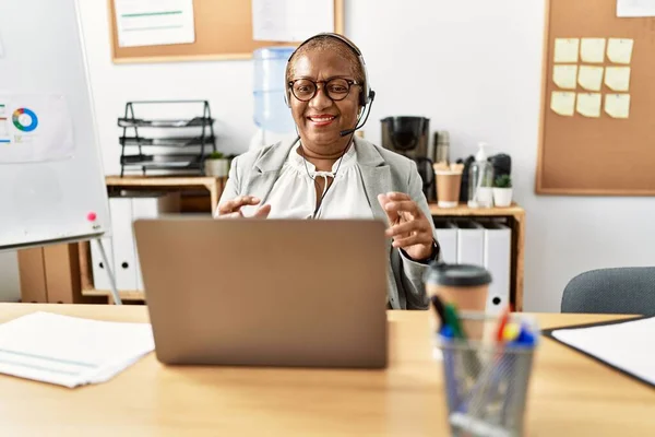 Senior african american woman call center agent having video call at office