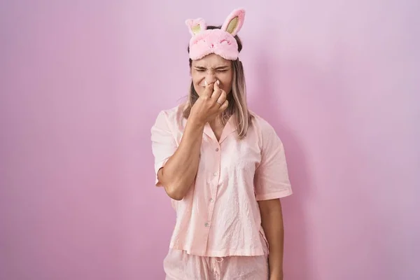 ブロンドの白人女性は 睡眠マスクとパジャマを着て 臭いと嫌な 耐えられない匂いを嗅ぎ 鼻の上に指で息を保持します 臭いが悪い — ストック写真