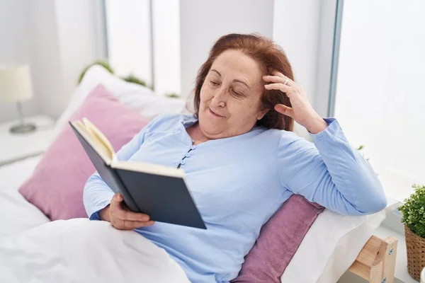 Старшая Женщина Читает Книгу Сидя Кровати Спальне — стоковое фото