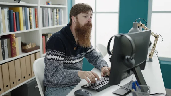 Young Redhead Man Student Using Computer Studying Library University — Stock fotografie