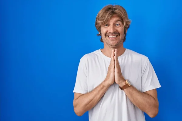 Middle Age Man Standing Blue Background Praying Hands Together Asking — Stock Photo, Image