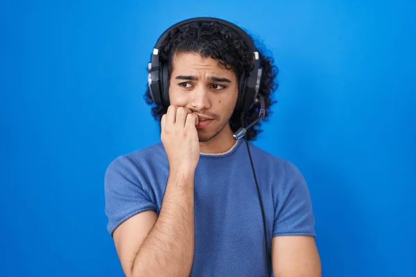 Hispanic Man Curly Hair Listening Music Using Headphones Looking Stressed — Stock Photo, Image