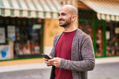 Sokakta akıllı telefon kullanan kendine güvenen genç adam.