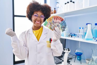 Genç Afrikalı Amerikalı kadın bilim adamlarının laboratuarında çalışıyor gururla bağırıyor, zaferi ve başarıyı kutluyor. 