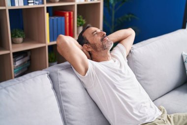 Çağrı merkezi kulaklığı takan orta yaşlı bir adam mutlu bir gülümseme ve el kaldırarak zaferi kutluyor. 