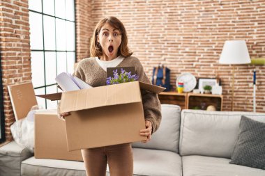 Genç, güzel bir kadın yeni evine taşınıyor. Şaşırmış ve şaşırmış bir ifade, korku ve heyecanlı bir yüz ifadesi var.. 