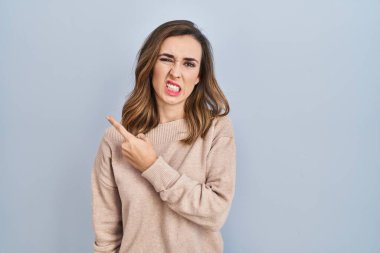 İzole edilmiş arka planda duran genç bir kadın endişeli ve endişeli bir ifade takınıyor. 