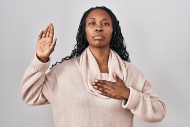 Beyaz arka planda duran Afrikalı bir kadın. Göğüs ve avuçlar açık yemin ederek sadakat yemini ediyor. 