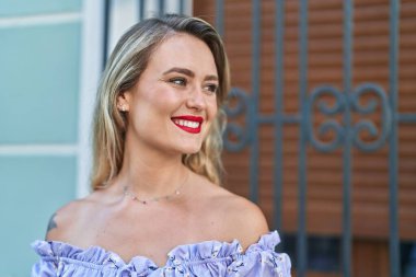 Young beautiful hispanic woman smiling confident looking to the side at street