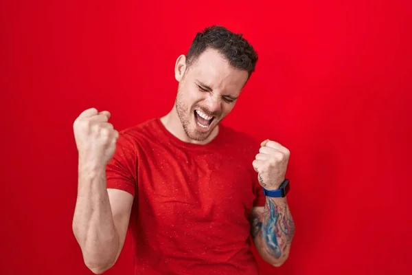 Kırmızı Arka Planda Duran Genç Spanyol Adam Çok Mutlu Heyecanlı — Stok fotoğraf
