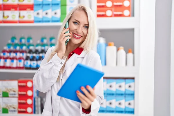 Young Blonde Woman Pharmacist Using Touchpad Talking Smartphone Pharmacy — Foto Stock