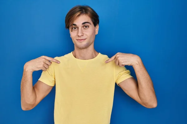 Young Man Standing Blue Background Looking Confident Smile Face Pointing — Stock Photo, Image