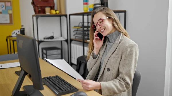 Młody Kaukaski Kobieta Biznes Pracownik Mówi Smartfon Czytanie Dokument Biuro — Zdjęcie stockowe