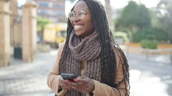 非洲妇女在街上用智能手机微笑 — 图库照片