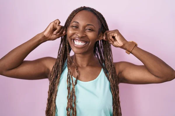 Mujer Afroamericana Pie Sobre Fondo Rosa Sonriendo Tirando Las Orejas — Foto de Stock