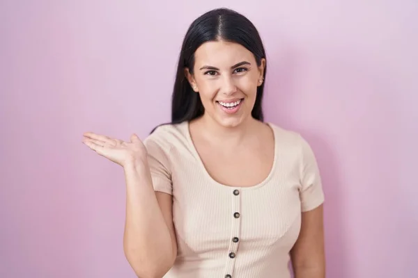 Young Hispanic Woman Standing Pink Background Smiling Cheerful Presenting Pointing — Φωτογραφία Αρχείου