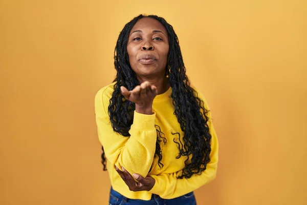 African Woman Standing Yellow Background Looking Camera Blowing Kiss Hand — стокове фото