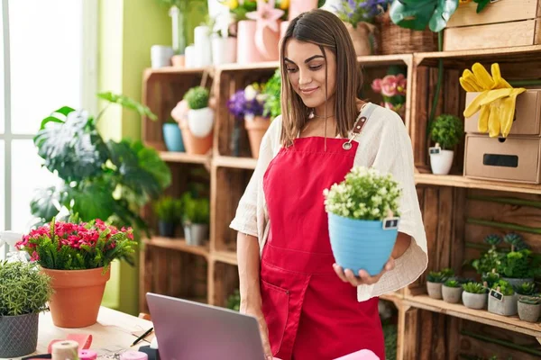 Jovem Bela Florista Mulher Hispânica Usando Laptop Segurando Planta Loja — Fotografia de Stock