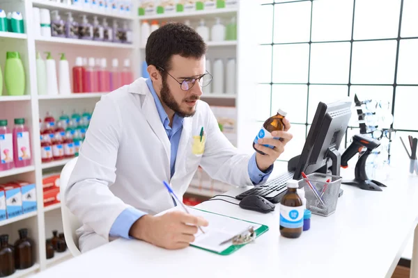 Jeune Homme Hispanique Pharmacien Tenant Bouteille Médicaments Écrit Sur Document — Photo