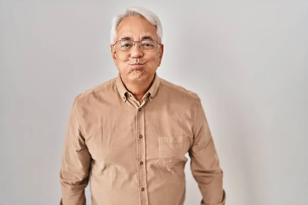 Hispanic Senior Man Bär Glasögon Puffande Kinder Med Roligt Ansikte — Stockfoto