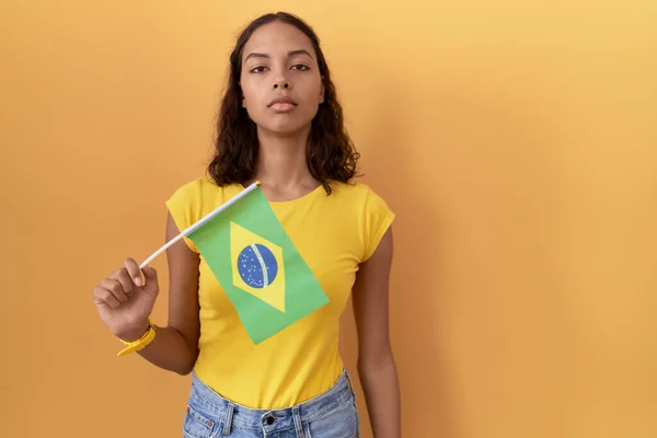 Mujer Hispana Joven Sosteniendo Bandera Brasileña Relajada Con Expresión Seria — Foto de Stock