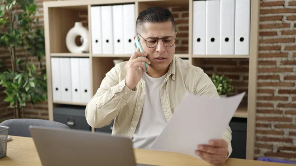 Νεαρός Ισπανός Επιχειρηματίας Μιλώντας Στο Τηλέφωνο Διαβάζοντας Έγγραφο Στο Γραφείο — Φωτογραφία Αρχείου
