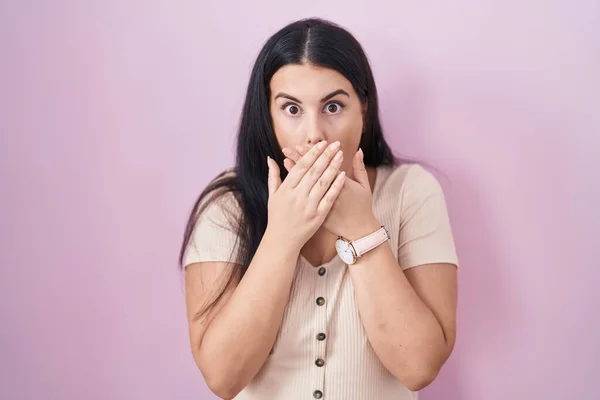 Junge Hispanische Frau Steht Über Rosa Hintergrund Schockiert Bedeckt Mund — Stockfoto