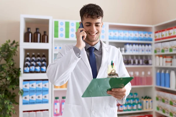 Young Hispanic Man Pharmacist Talking Smartphone Reading Document Pharmacy — Stock Photo, Image